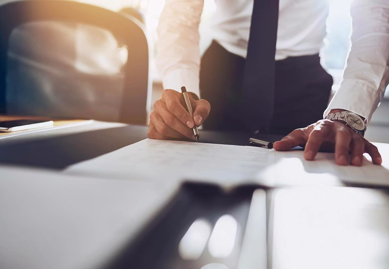 One of our California accident attorneys stands over their desk, taking in the scope of case-related documents before them.