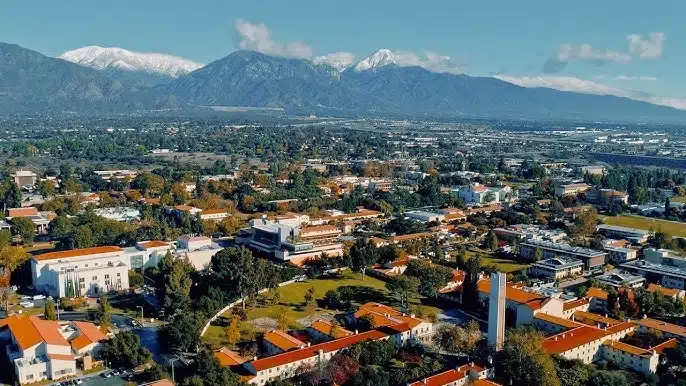 Aerial view of a campus town with snow-capped mountains in the background.