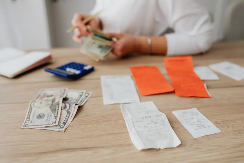 Illustration of medical bills, a damaged car, and insurance documents representing payment responsibility after a California car accident.