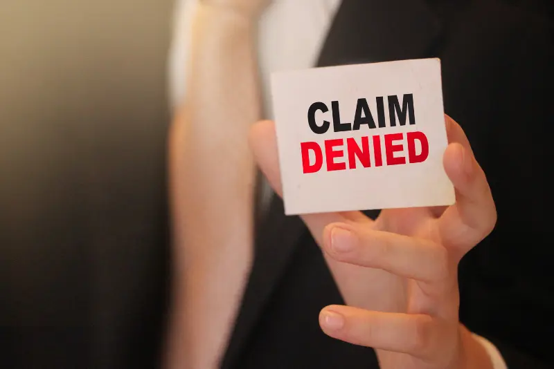Illustration representing denied personal injury claims in California, featuring legal documents, a rejected claim stamp, and courthouse imagery.